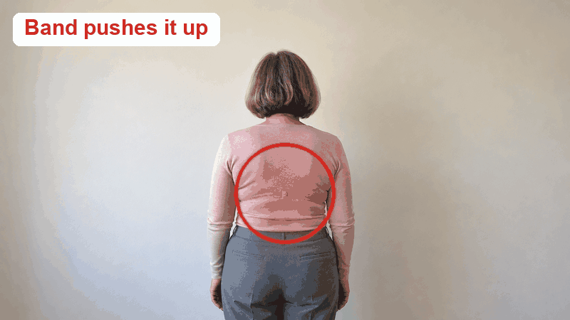 From behind in a fitted blouse: a bra band pushes up a roll, in the tank her back is smooth